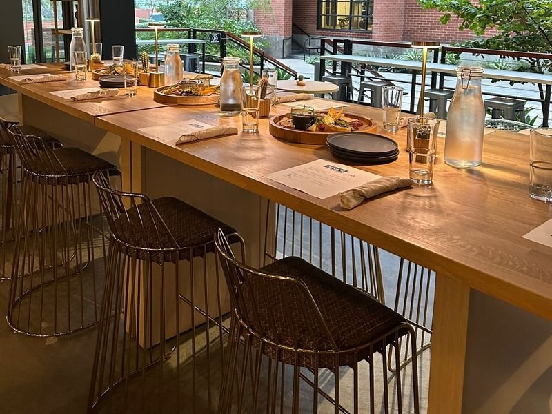 The long table at Therapie Bistro, set for a group, with the courtyard beyond